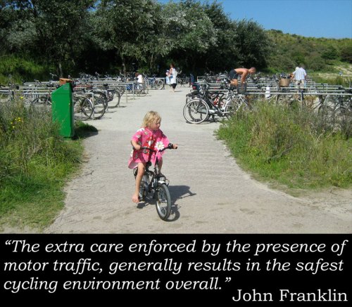 Photo of a young girl (aged about three?) riding her bike without any fear as there are no cars around, with John Franklin quote: "The extra care enforced by the presence of motor traffic, generally results in the safest cycling environment overall."