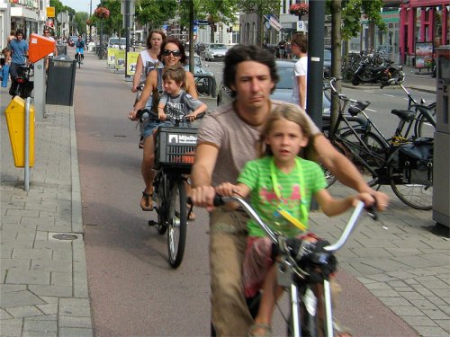 A family riding bikes on a cycle path in the Netherlands.