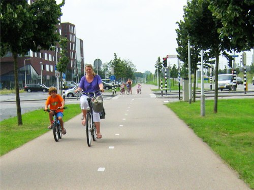 A woman and her son ride safely along a cycle path in the Netherlands.