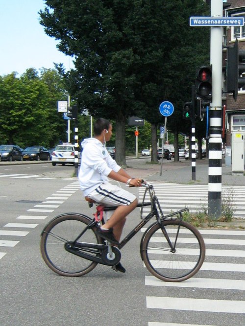 A boy rides his bike across a junction in Holland.