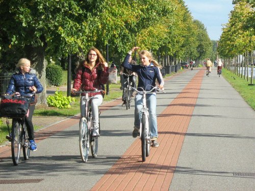 Three Dutch girls ride home on a 'bicycle road' alongside the canal in the Netherlands.
