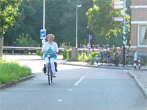 An older woman rides a bike on the safe cycle infrastructure in the Netherlands