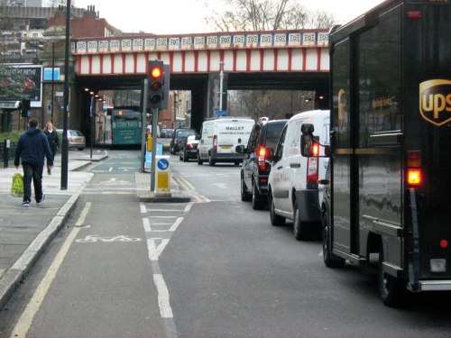 A rare example of infrastructure which enables a bike rider to continue while motor vehicles are held at a red light. This is possible because the cycle path runs to the side of the lights, and a bike user is not interacting with the conflicting flow of traffic.