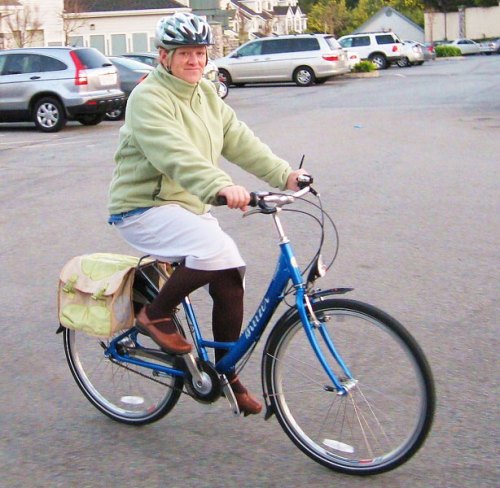 A middle-aged woman riding a bike.