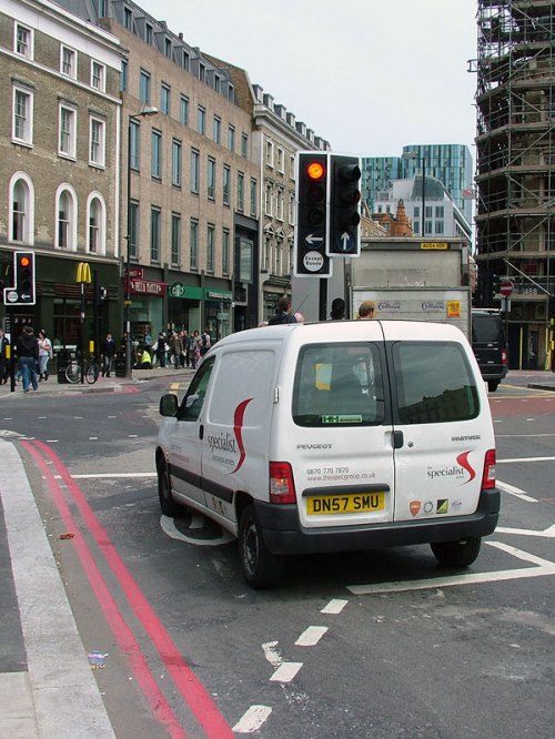 A van is stopped at a red light, completely within the 'Advance Stopping Zone' for bike users.