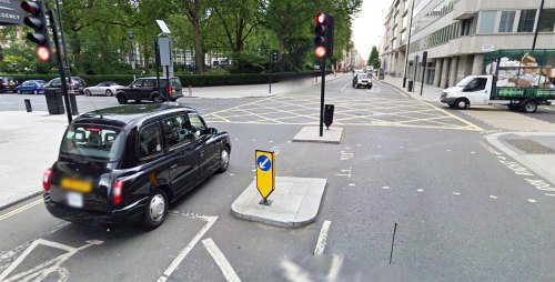 A photograph of Portman Street and Seymour Street in Westminster, a crossroads with traffic lights for vehicles but nothing for people walking.