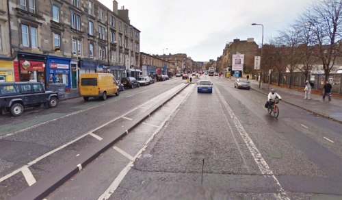 A photograph of Leith Walk in Edinburgh, showing the wide road and unused space in the middle.