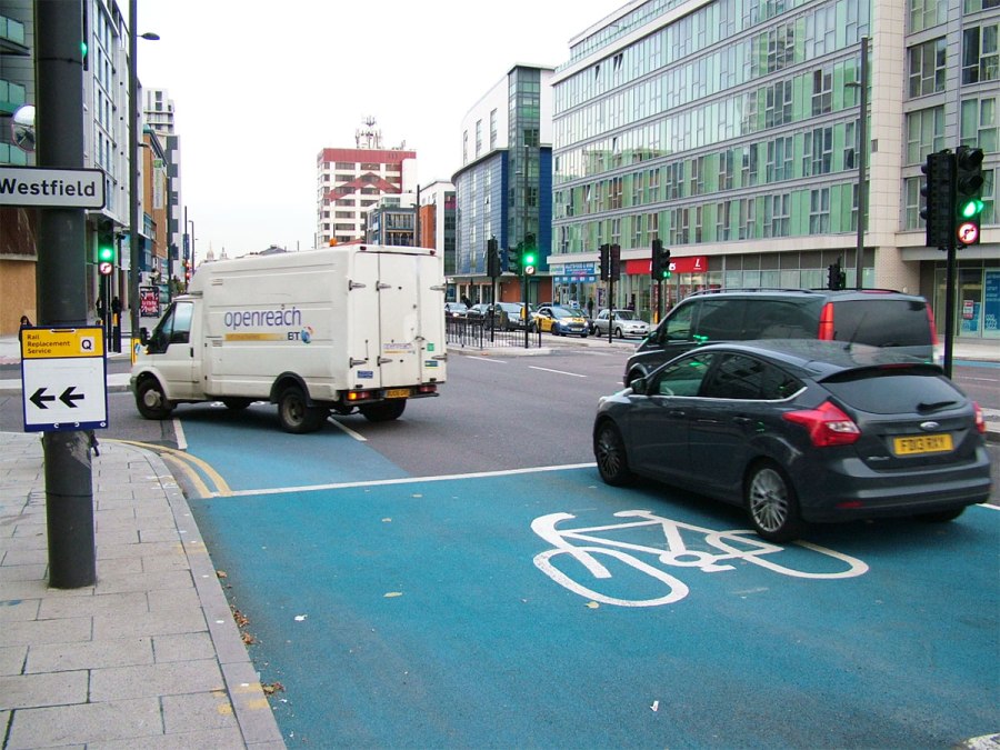A van turns left while cyclists are green to go straight on, on CS2 at Stratford