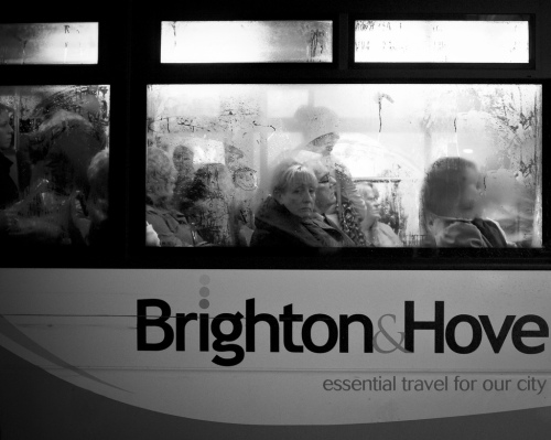 Photo of a crowded bus with steamy windows. An unhappy-looking woman looks out of the window.