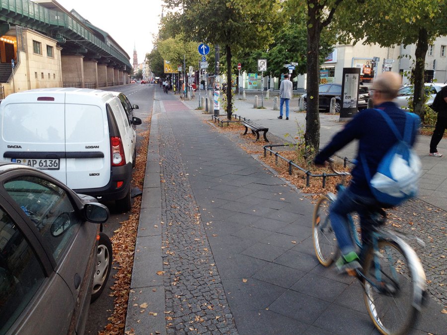 One of Berlin's better cycleways. Not too narrow, but a tiled surface and a low fence which pedals could hit. Also right next to parked cars with only a tiny buffer.
