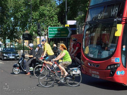 A photo of a late-middle-aged woman riding a bike in the Netherlands has been cut out and pasted into a London traffic scene, scarily close to a bus