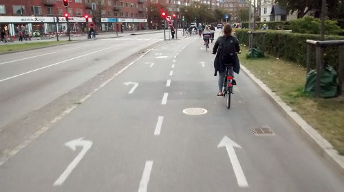 People ride bikes on a very wide and smooth cycleway in Copenhagen